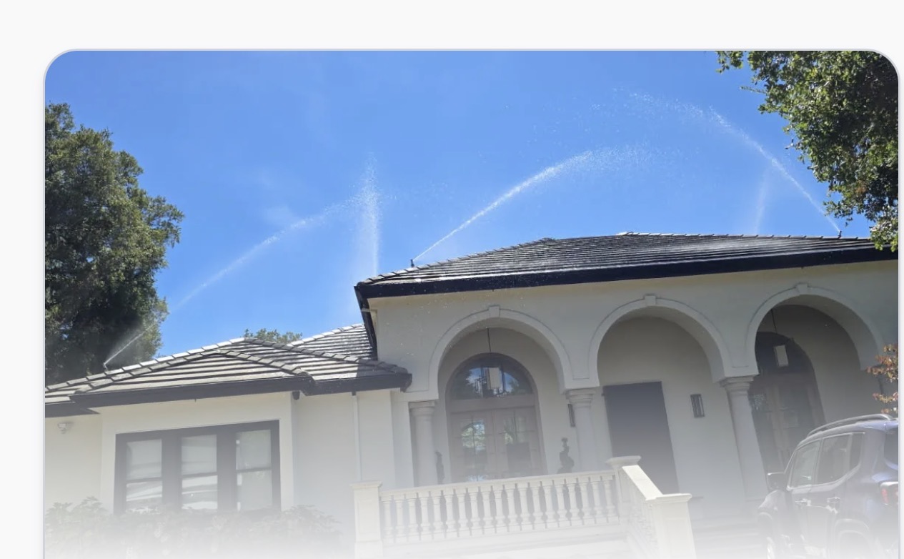 FireRoofs exterior sprinklers actively spraying water arcs over a home roof during a live system test