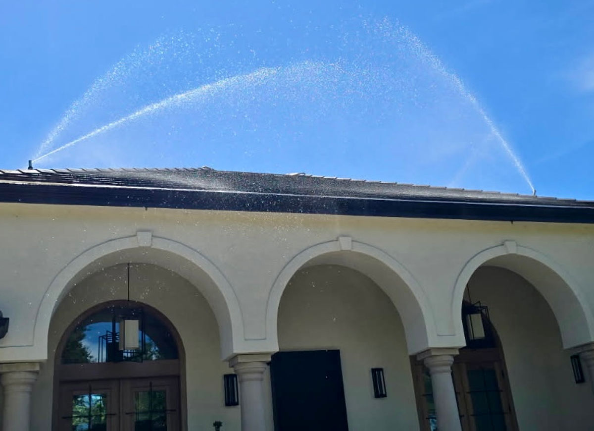 FireRoofs exterior wildfire sprinklers running at full deployment on a Saratoga hilltop estate in the Santa Cruz Mountains
